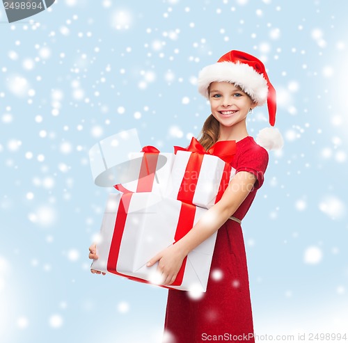 Image of girl in santa helper hat with many gift boxes