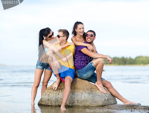 Image of group of friends having fun on the beach