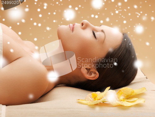 Image of woman in spa salon lying on the massage desk