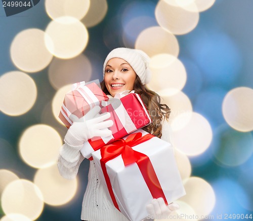 Image of woman in sweater and hat with many gift boxes