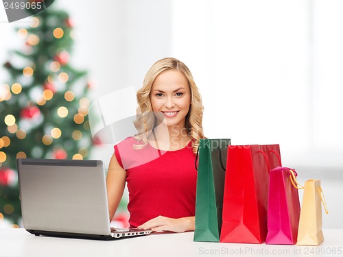 Image of woman with shopping bags and laptop computer
