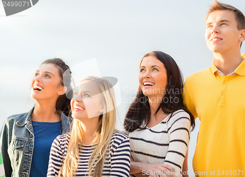 Image of group of friends looking up on the beach