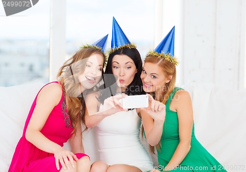 Image of three women in hats having fun with camera