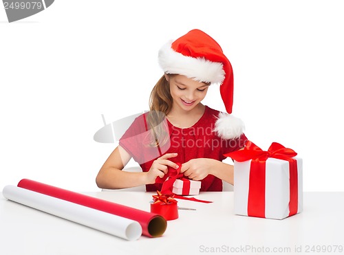 Image of smiling girl in santa helper hat with gift box
