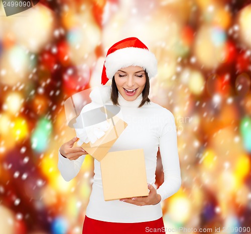 Image of surprised woman in santa helper hat with gift box