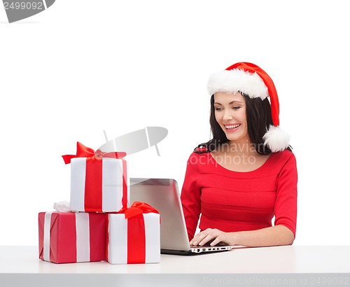 Image of woman with gift boxes and laptop computer