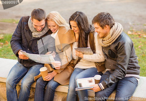 Image of couples with tourist map in autumn park