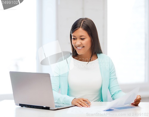 Image of asian businesswoman with laptop and documents