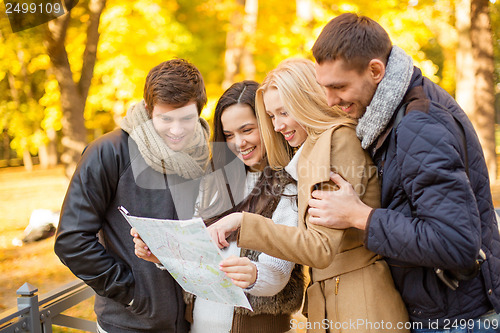 Image of couples with tourist map in autumn park