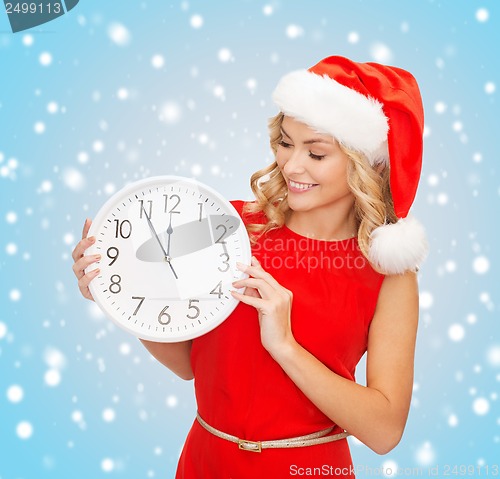 Image of woman in santa helper hat with clock showing 12