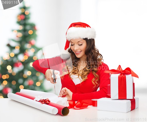 Image of smiling woman in santa helper hat with gift box