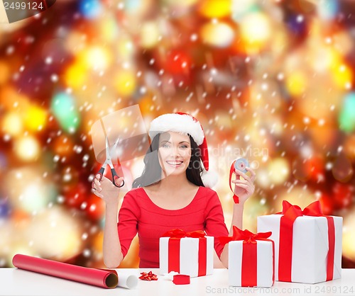 Image of woman in santa helper hat with many gift boxes