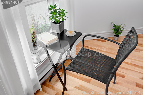 Image of Chair and table in a room with green plants