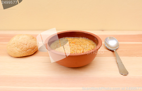 Image of Hearty lentil soup served with a crusty bread roll