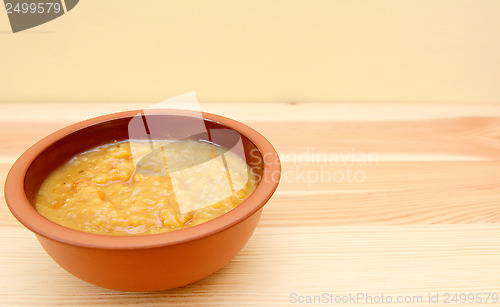 Image of Closeup of bowl of vegetable soup on a wooden table