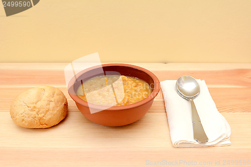 Image of Vegetable soup in a bowl with crusty bread roll