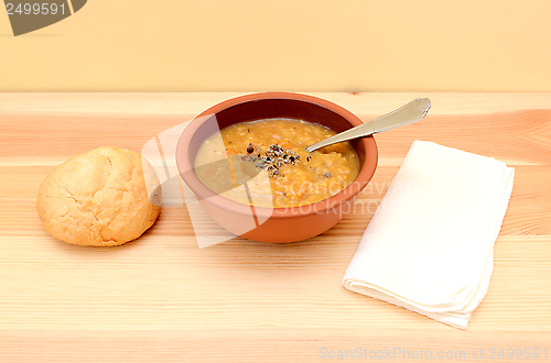 Image of Lentil soup in a bowl with seasoning and bread roll
