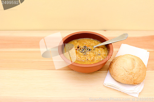 Image of Vegetable soup served with seasoning and bread roll