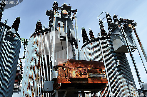 Image of old rusty transformer substation against the blue sky