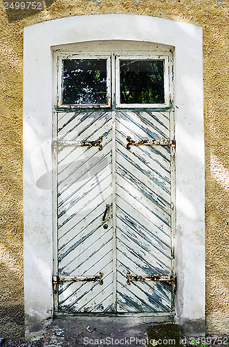 Image of wooden white door with wrought-iron hinges