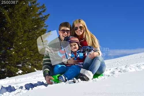 Image of family having fun on fresh snow at winter vacation