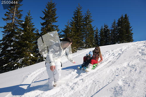 Image of family having fun on fresh snow at winter vacation