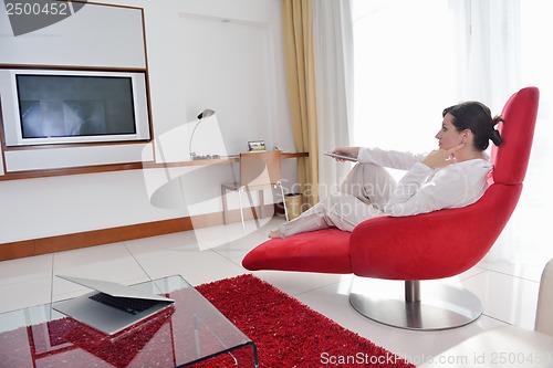 Image of happy young woman relax at home on sofa
