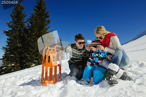 Image of family having fun on fresh snow at winter vacation