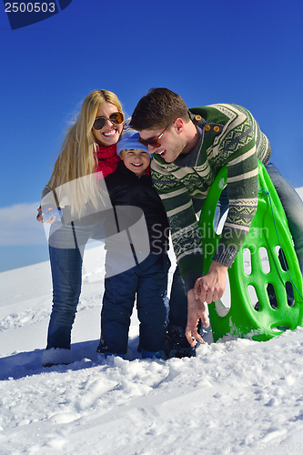 Image of family having fun on fresh snow at winter vacation