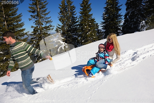 Image of family having fun on fresh snow at winter vacation