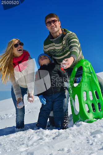 Image of family having fun on fresh snow at winter vacation