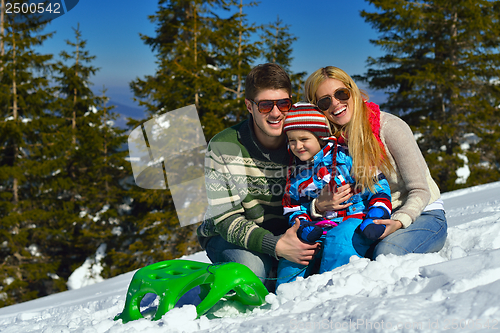 Image of family having fun on fresh snow at winter vacation