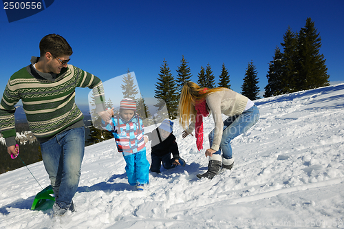 Image of family having fun on fresh snow at winter vacation