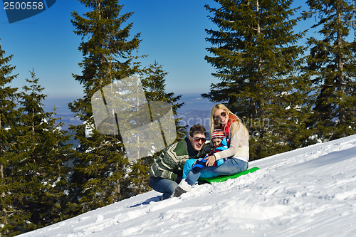 Image of family having fun on fresh snow at winter vacation