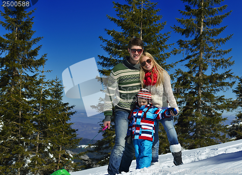 Image of family having fun on fresh snow at winter vacation