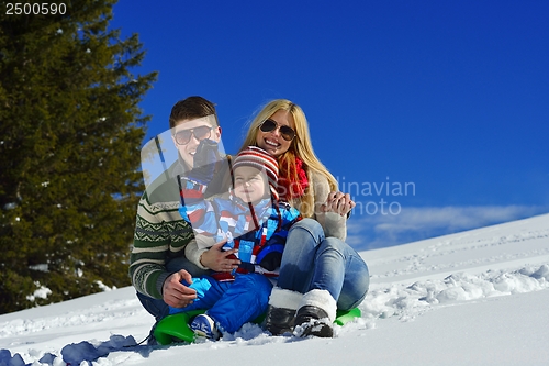 Image of family having fun on fresh snow at winter vacation