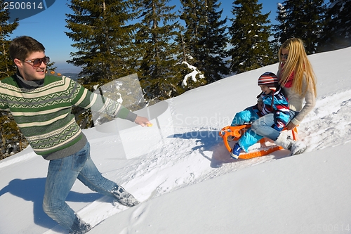 Image of family having fun on fresh snow at winter vacation