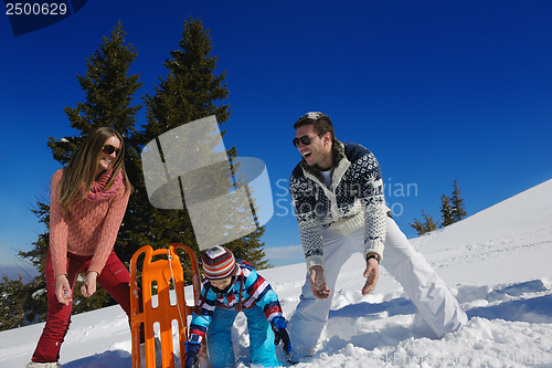 Image of family having fun on fresh snow at winter vacation