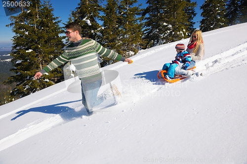 Image of family having fun on fresh snow at winter vacation