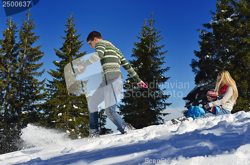 Image of family having fun on fresh snow at winter vacation