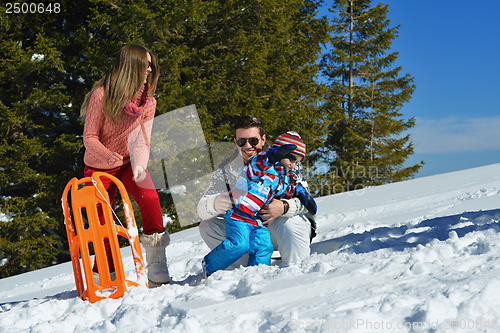 Image of family having fun on fresh snow at winter vacation