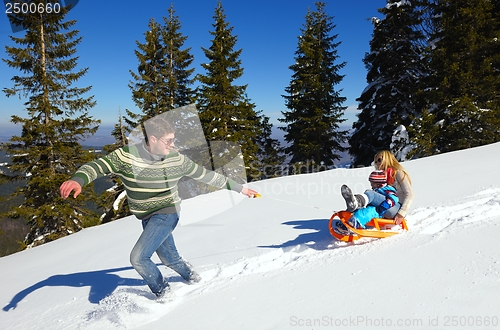 Image of family having fun on fresh snow at winter vacation