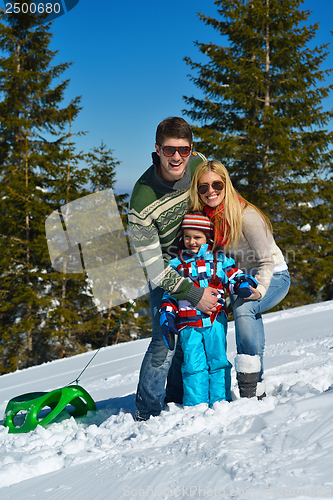 Image of family having fun on fresh snow at winter vacation