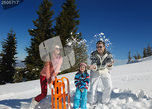 Image of family having fun on fresh snow at winter vacation
