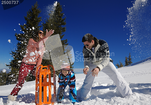 Image of family having fun on fresh snow at winter vacation