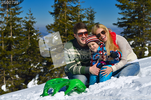 Image of family having fun on fresh snow at winter vacation