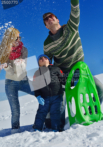 Image of family having fun on fresh snow at winter vacation
