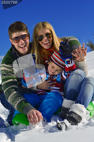 Image of family having fun on fresh snow at winter vacation