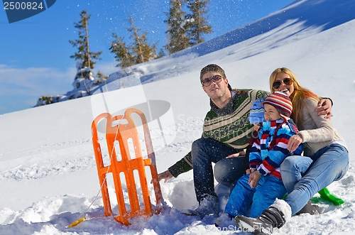 Image of family having fun on fresh snow at winter vacation