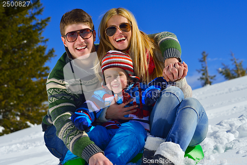 Image of family having fun on fresh snow at winter vacation